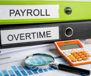 Payroll and Overtime. Binder data finance report business with graph analysis in office.